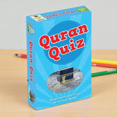 Quran Quiz packaging with a blue background and text on a wooden surface.